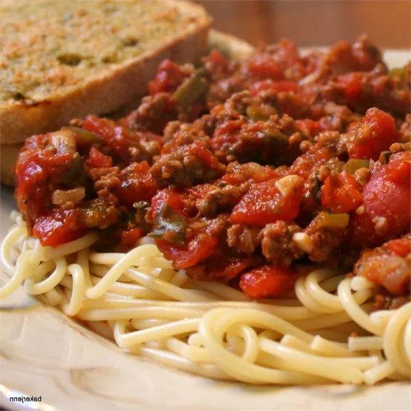 Een hoop groentensaus met spaghetti en worst